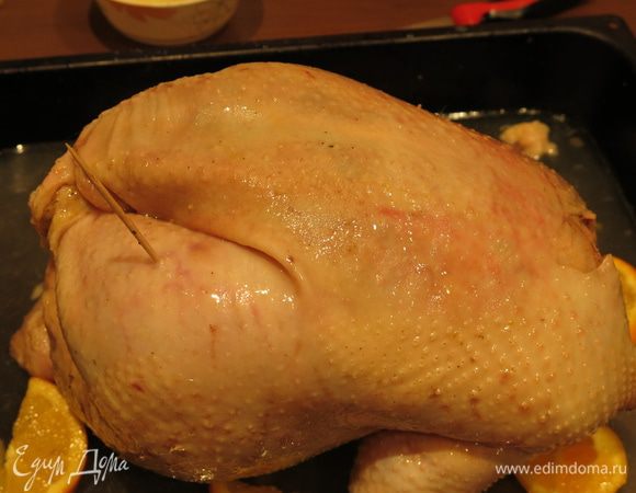 Кладем тушку на противень. Делаем несколько проколов зубочисткой в коже. Наливаем в противень маринад, чашку воды, если птица жирная и вы срезали излишки, кладем кусочки жира на растопку.