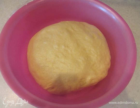 Обмять тесто, снова затянуть емкость пищевой пленкой и отправить тесто на вторую расстойку в теплое место на 45 минут.