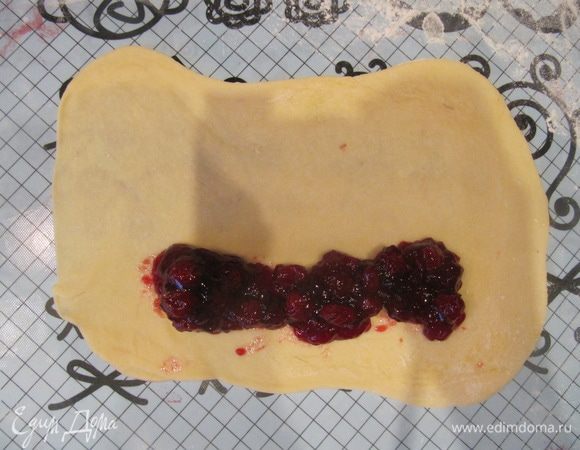 На присыпанной мукой рабочей поверхности раскатать каждый кусочек теста в тонкий прямоугольник, выложить по длинной стороне прямоугольника джем (он должен быть густым!), немного не доходя до краев по бокам.