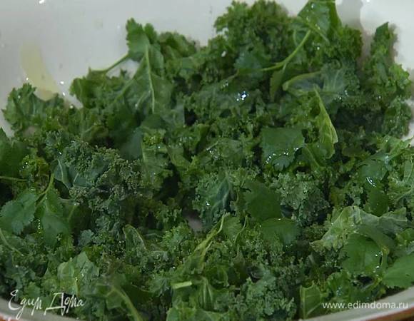 Кейл мелко порвать (если листья грубоваты, можно слегка помять руками), выложить на блюдо, посолить, поперчить, полить выжатым из половинки лимона соком, посыпать измельченными руками листьями кинзы и сбрызнуть оставшимся оливковым маслом Extra Virgin.