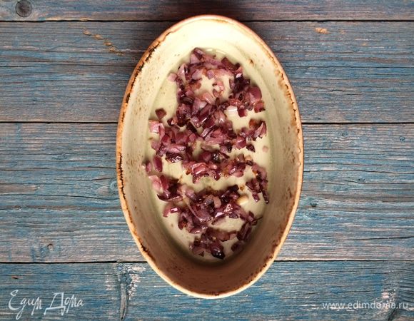 Лук очистите и мелко нарежьте. Разогрейте в сковороде 1 ст. л. растительного масла и обжарьте лук на среднем огне до золотистого цвета. Переложите в емкость для запекания.