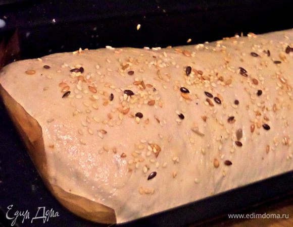 Дать расстояться в форме около часа. Посыпать смесью семечек (также семечки можно добавить и внутрь теста) и выпекать вначале при 200°С, потом уменьшить до 190°С. 