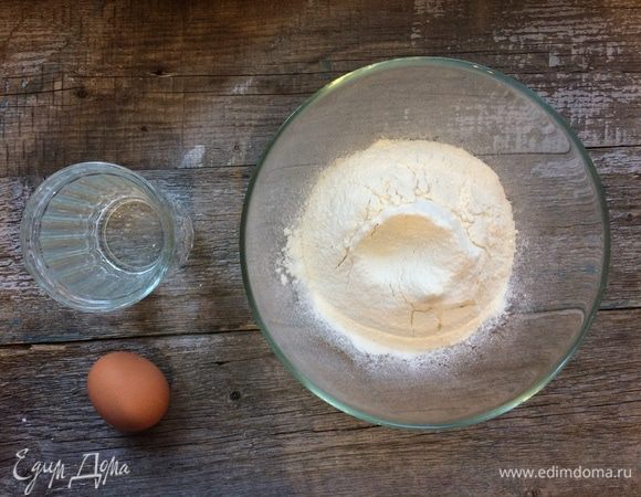 Муку просейте горкой, в центре сделайте углубление.