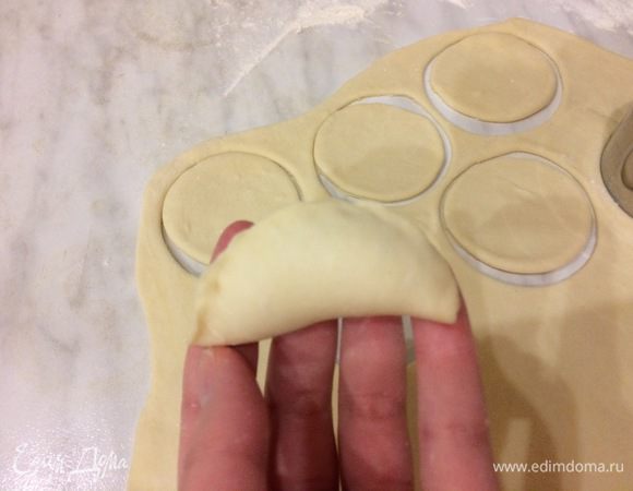 Положите на ладонь кружок теста с начинкой и аккуратно защипните края. Соедините концы полумесяца и скрепите их, плотно прижмите пальцами, чтобы концы склеились.