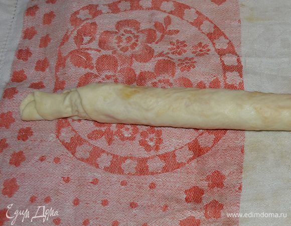 Заворачиваем пласт с начинкой в рулет. Скатываем достаточно плотно. 
