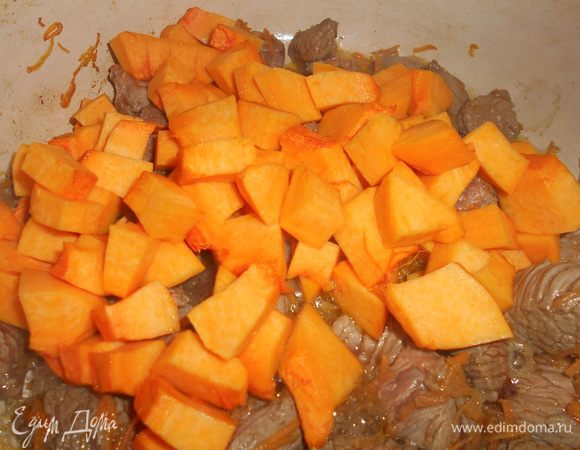 Добавляем к мясу тыкву, очищенную от кожицы и семян и нарезанную кубиками. Перемешиваем, притушиваем минут 5.
