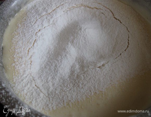 Муку смешать с кукурузным крахмалом, просеять на взбитые яйца, аккуратно перемешать и добавить растопленное сливочное масло.
