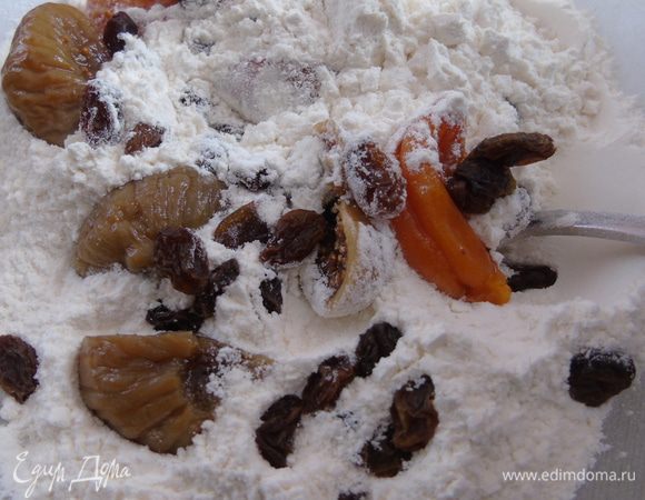 Муку  просеиваем и смешиваем с разрыхлителем. С инжира и кураги сливаем чай, разрезаем на половину и вместе с  изюмом добавляем в муку. Осторожно перемешиваем руками.