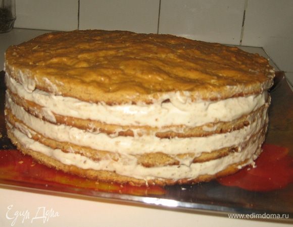 Собираем торт, намазывая кремом коржи, все, корме верхнего. У меня, как видите, четыре коржа, и крема довольно много (он хорошо впитывается в коржи, за счет этого они еще больше утолщаются). Поэтому я для крема взяла почти 2 стакана сметаны.