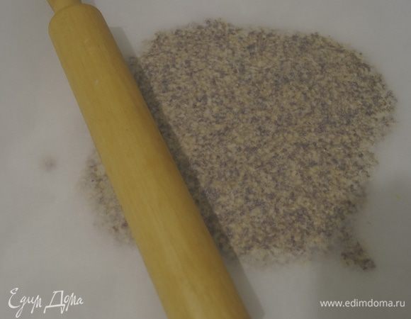 Выложить горячую массу на бумагу для выпечки, накрыть вторым листом и раскатать в тонкий пласт, насколько это возможно.