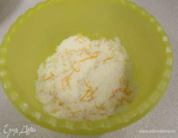 Смешать сахар с апельсиновой цедрой, перетереть руками, пока сахар не станет мокрым.