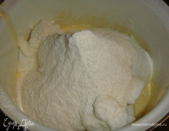 В желтки просеять по 50 г муки и крахмала. Перемешать. Выложить белковую массу и аккуратно перемешать сверху-вниз.