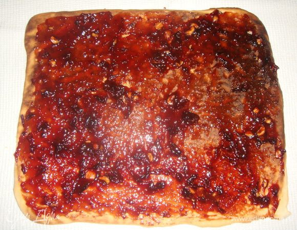 Готовый корж выложить на полотенце, присыпанное сахаром, смазать 1/2 джема.