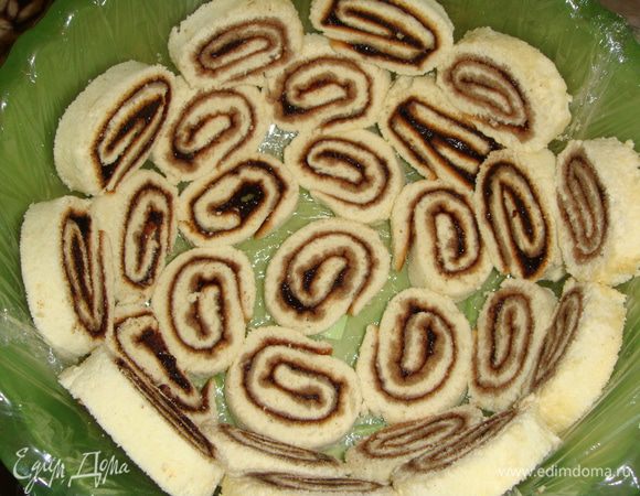 Форму для торта застелить пищевой пленкой. Выложить кусочками рулета дно и стенки формы. Оставить несколько кусочков, чтобы выложить верх (у меня ушло 16 штучек).
