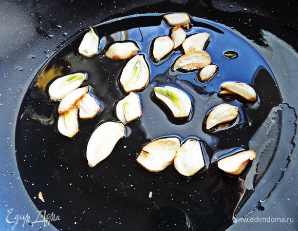 Налить в сковороду вок растительное масло и обжарить в нем чеснок.