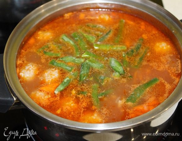 Добавьте замороженную фасоль. Размораживать ее не надо. Доведите суп до кипения.
