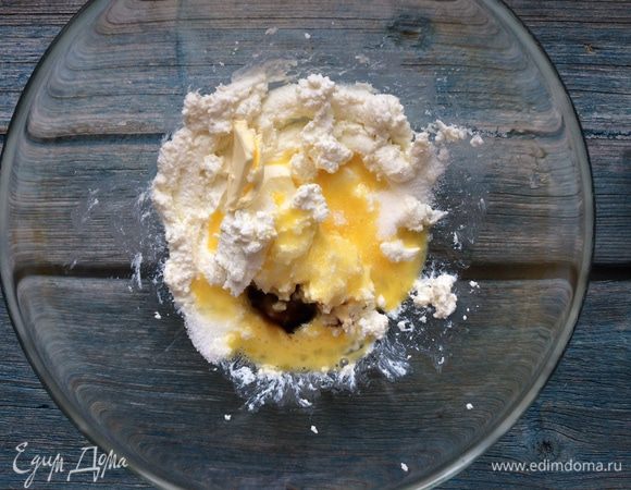 Добавьте к творогу масло, сахар, яйцо и ванильную эссенцию, хорошо перемешайте.