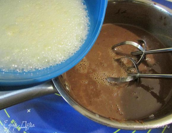 Яйца ввести в шоколад, быстро перемешать и слегка взбить миксером до однородности.