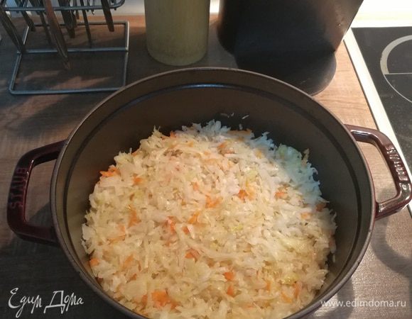 Капусту квашеную уложить на дно посуды и равномерно распределить по всей поверхности