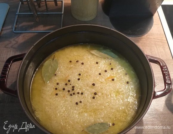 Аккуратно заливаем бульон так, чтобы он распределился по всей поверхности, залил наши два слоя из капусты и риса и выступал на 1 см. Добавляем соль, перец и лавровый лист.