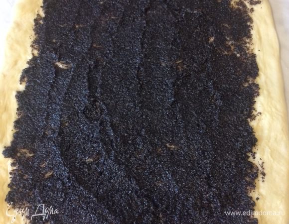 Раскатайте тесто на присыпанной мукой поверхности в прямоугольный пласт размером 10 на 15 см. Смажьте маковой начинкой, оставив по 1 см с каждой стороны.