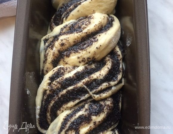 Форму смажьте сливочным маслом. Затем плетенную косу аккуратно переложите в подготовленную форму. Оставьте в теплом месте на 15 — 20 минут, накрыв полотенцем. Когда плетенная коса увеличится в объеме вдвое, аккуратно смажьте взбитым яйцом.