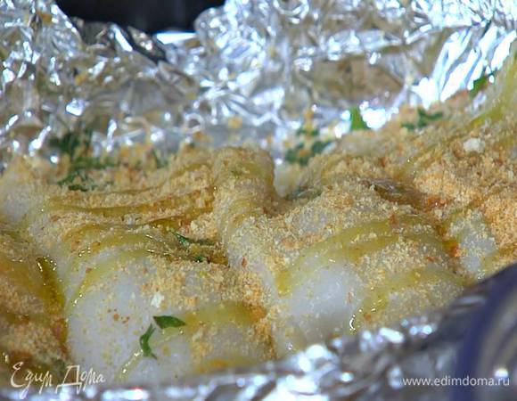 Наполнить тушки кальмаров начинкой, выложить в небольшой противень, выстеленный пищевой фольгой, посыпать все оставшимися сухарями и сбрызнуть оставшимся оливковым маслом.
