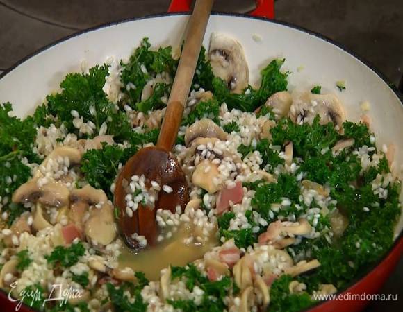 Влить 100 мл белого вина, увеличить огонь и, помешивая, прогреть, затем влить воду, в которой замачивались сухие белые грибы, и по одному половнику вливать горячий бульон, добавляя его по мере выкипания.