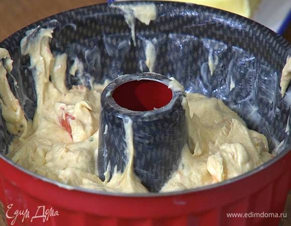 Форму для кекса с выемкой посередине смазать оставшимся сливочным маслом, выложить тесто и разровнять его.