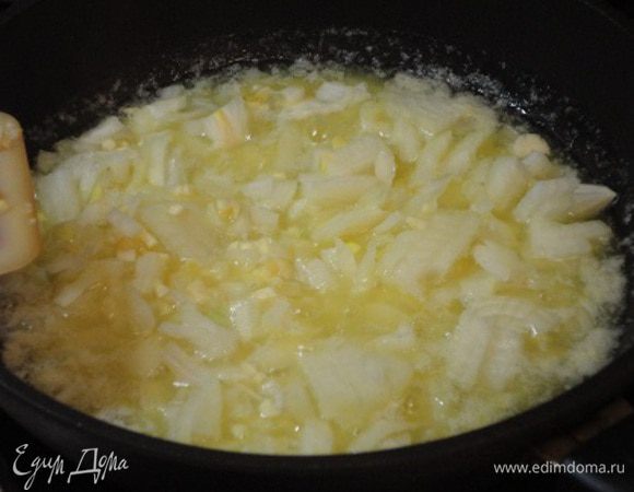 Лук и чеснок нарезать мелкими кубиками и обжарить в глубокой сковороде на смеси растительного и сливочного масла.