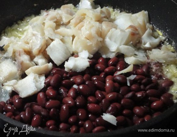 Сюда же выложить рыбу и фасоль, посолить и поперчить по вкусу и держать на небольшом огне 15 минут.