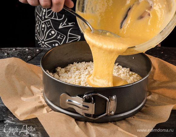 Смазать разъемную форму растительным маслом, вылить половину теста, затем выложить и аккуратно распределить творожную массу, залить второй половиной теста.