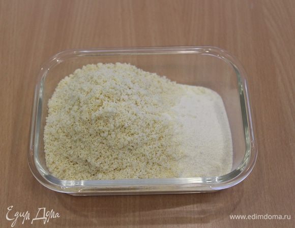 Яблоки очистить, удалить сердцевину, разрезать на половинки. Сделать на каждой половинке продольные разрезы глубиной примерно 5 мм, отложить в сторону.
Смешать манную крупу, молотый миндаль, муку и разрыхлитель.