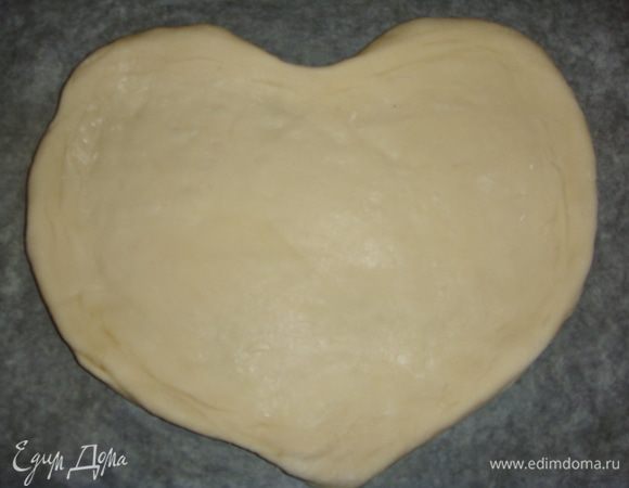 Противень застелить пергаментом. Большую часть теста раскатать и переложить на противень. Придать тесту форму сердца, сделав небольшие бортики.