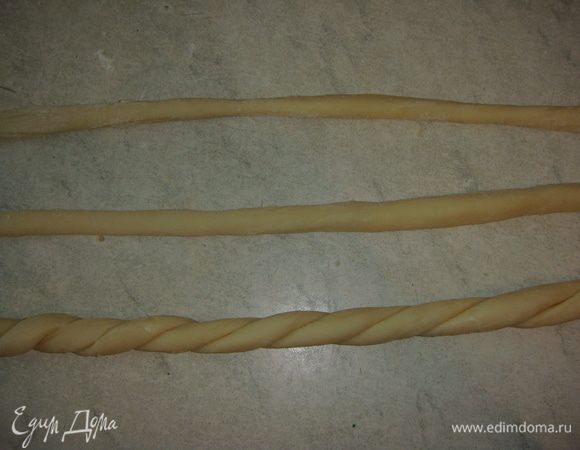 От третьей части теста отрезать 4 кусочка. Скатать из них жгутики. Переплести между собой по два жгутика.