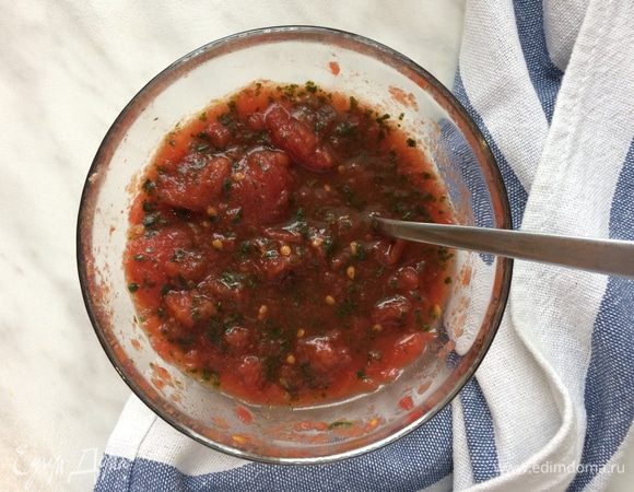 Помидоры нарежьте (сок из банки слейте в стеклянную банку и уберите в холодильник, он нам не понадобится). Мелко порубите листья базилика, мелко натрите лимонную цедру и перемешайте то и другое с помидорами, парой ложек уксуса и большой щепоткой морской соли.