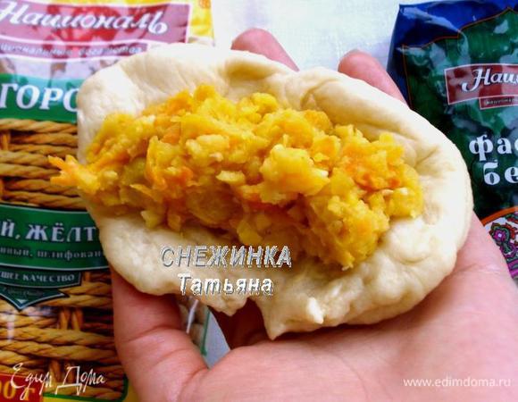 Гороховые пирожки я сделала продолговатой формы. Разминаем кусочек теста в продолговатую лепешку, распределяем начинку.