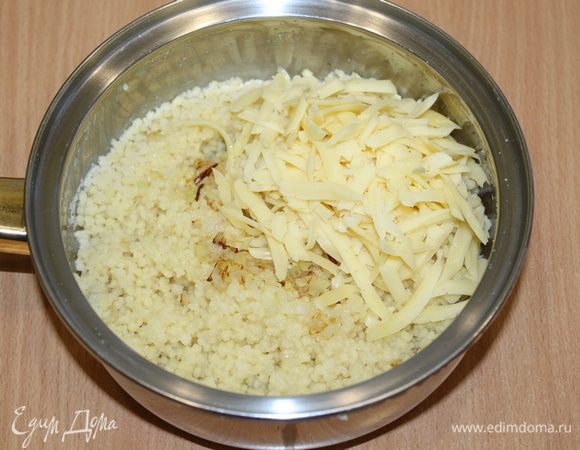 К готовому кускусу добавить мелко порезанный и обжаренный лук, натертый сыр. Перемешать.