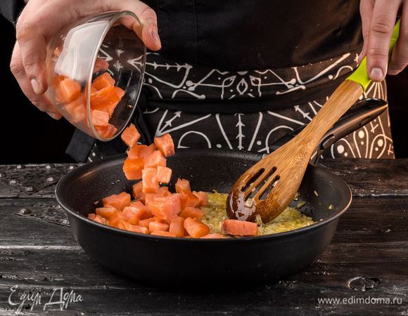 Рыбу нарезать небольшими кубиками (1 — 1,5 см), выложить в сковороду к луку и жарить пару минут на небольшом огне.