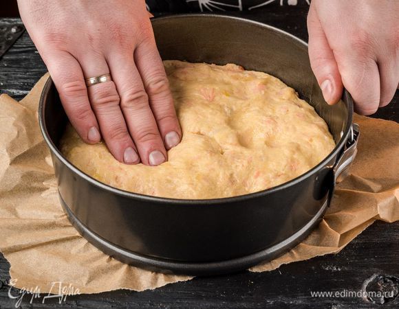 Смазать высокую форму для выпечки растительным маслом. Обмять подошедшее тесто и выложить в форму.