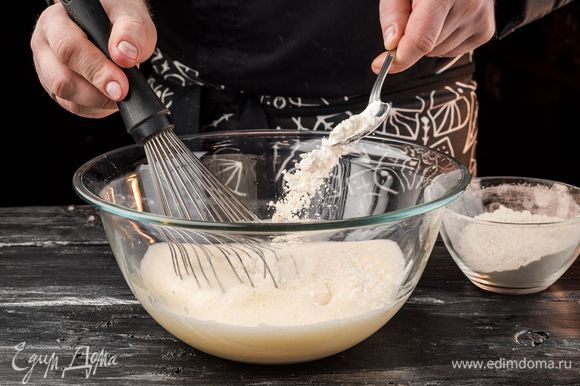 Муку соединить с содой и добавлять по ложке, постоянно взбивая. Затем добавить сахар и взбить до его полного растворения. Дать отдохнуть тесту 5 минут.
