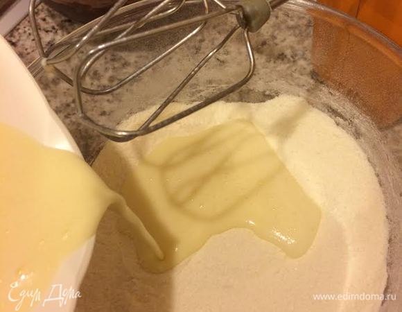 В муку добавить половину молочной смеси и взбить миксером.