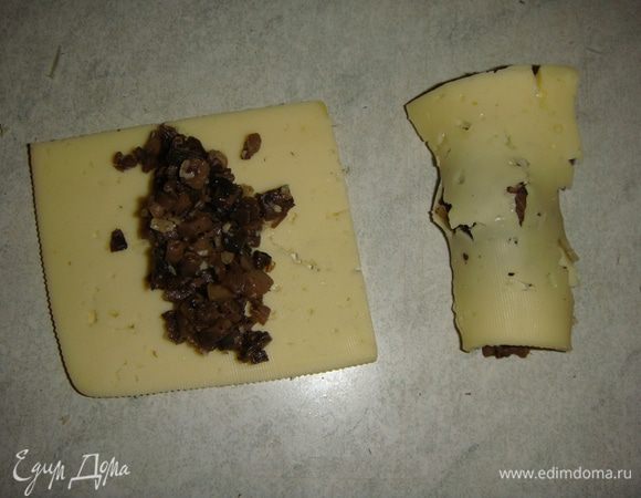 На кусочек сыра выкладываем грибы и сворачиваем в рулетик. Можно сыр нарезать брусочками. Я делала и так, и так, вкус от этого не меняется.