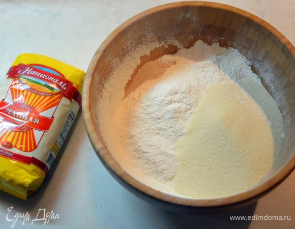 Отдельно соединить сухие ингредиенты: муку, манную крупу ТМ «Националь», разрыхлитель и дрожжи. Перемешать. Муки возьмите 400 г, далее будете добавлять по мере необходимости.