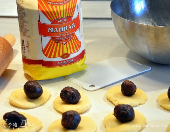 Раскатать из теста круглые лепешки, из финиковой пасты слепить шарики и выложить их на тесто. 