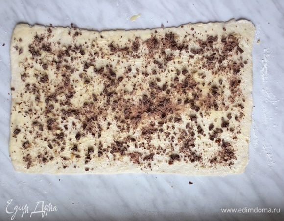 Затем равномерно распределите орехи и шоколадные капли и посыпьте корицей.