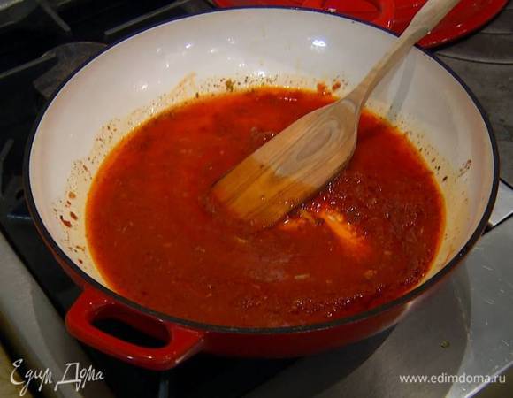 Разогреть в тяжелой сковороде оливковое масло, добавить томатную пасту и растертые специи, все перемешать и прогревать на маленьком огне несколько секунд, затем влить 50‒60 мл воды, увеличить огонь, все перемешать и еще немного прогреть.