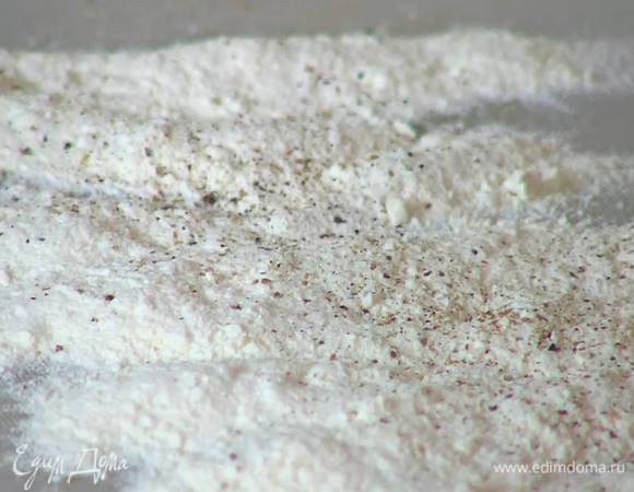 Муку насыпать на рабочую поверхность, посолить и поперчить.