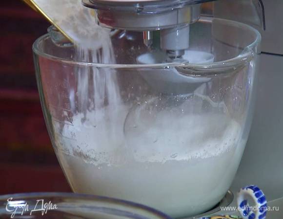 Белки взбивать в комбайне на высокой скорости, когда они начнут густеть, понизить скорость и небольшими порциями всыпать сахарную пудру и ванильный сахар, затем увеличить скорость и продолжать взбивать.