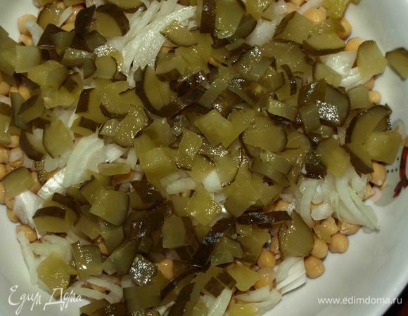 К 300 г готового нута добавить нашинкованный лук, мелко нарезанные огурцы.